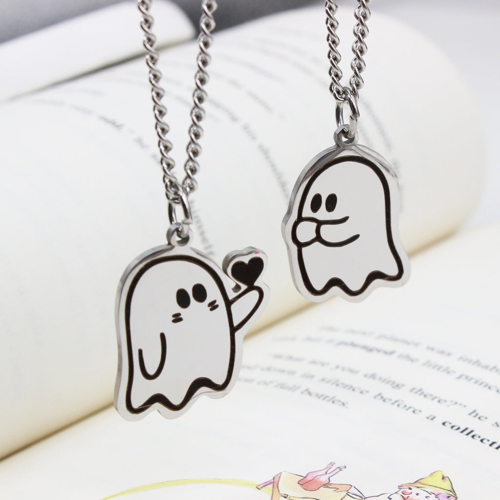 Gros plan des deux pendentifs fantôme en acier sur un livre ouvert